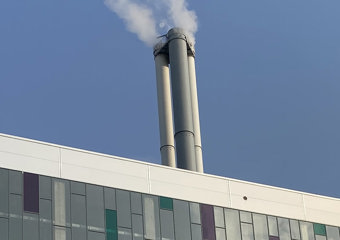 Toppen av byggning med pipe som det ryker fra