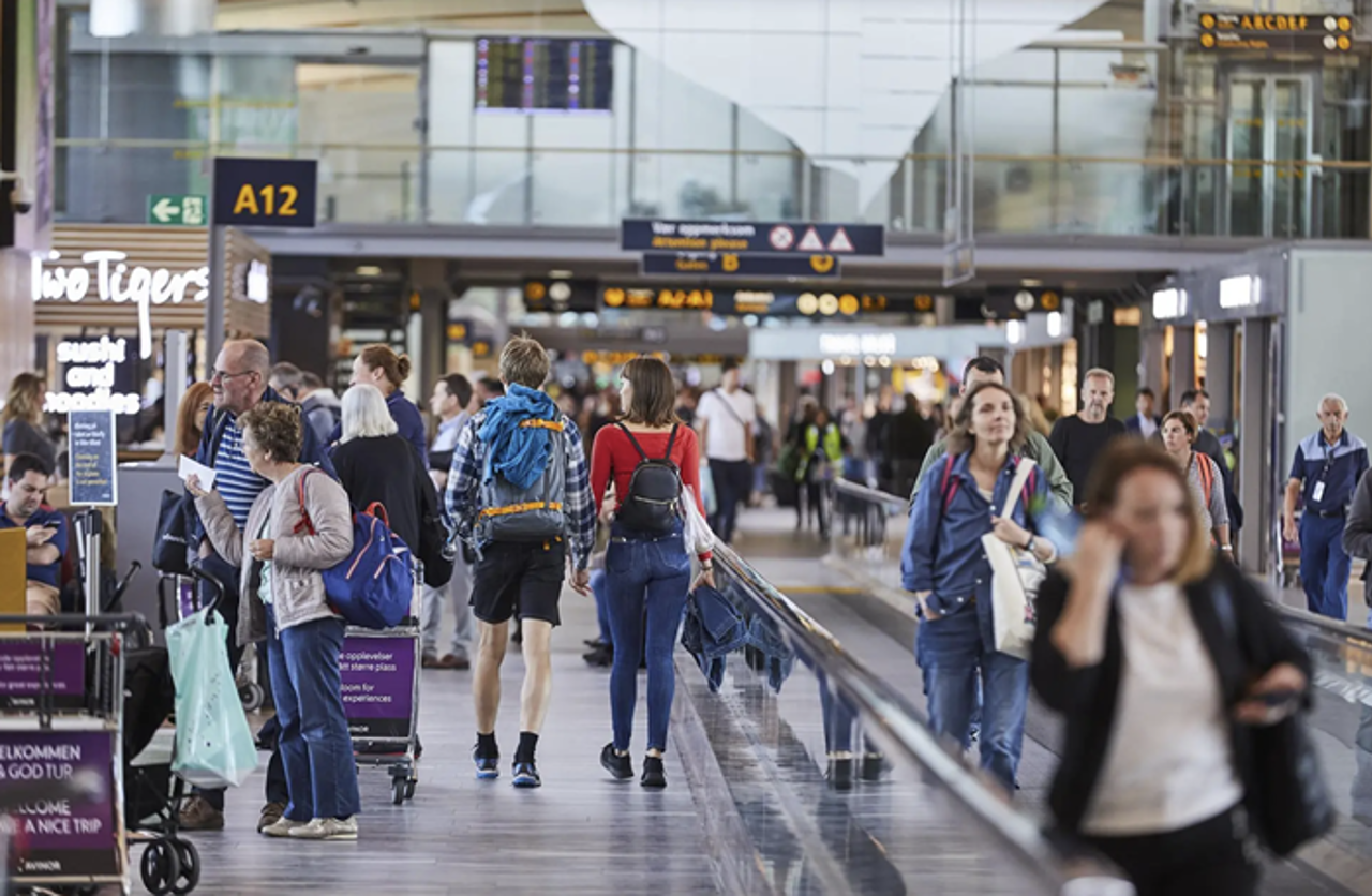 Bildet viser mange mennesker inne i en terminal p&aring; Gardermoen lufthavn. 