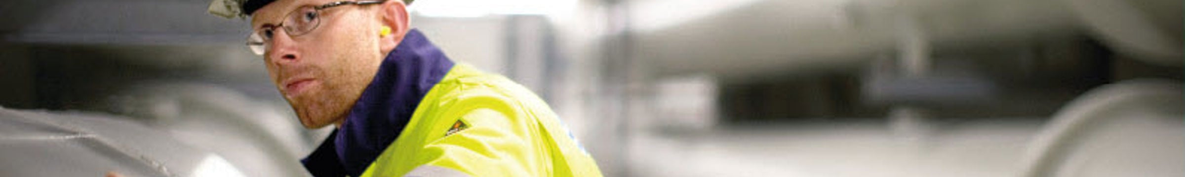 mann i arbeidsklær sjekker et rør
